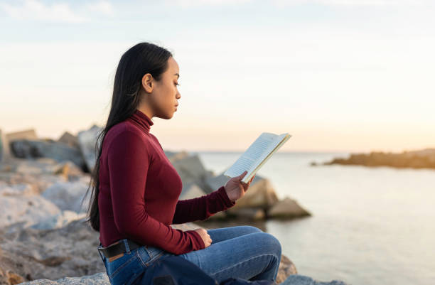 istock Beautiful young asian woman reading a book 1305179860
