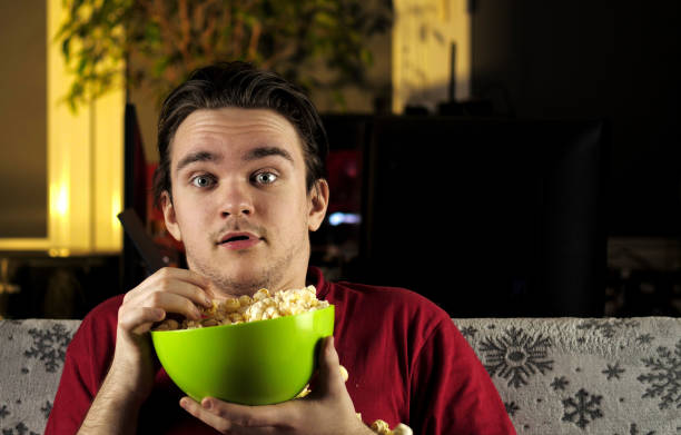 istock A young guy in a red T-shirt sits on the couch on which there is a white blanket 1305181804