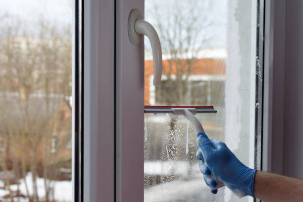 istock A man's hand in blue gloves holds a windshield wiper and wipes water from 1305183402