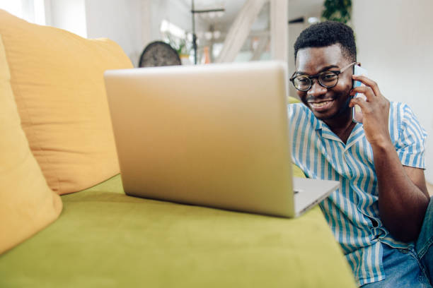 istock Young African-American telephoning while working online at home 1305189034