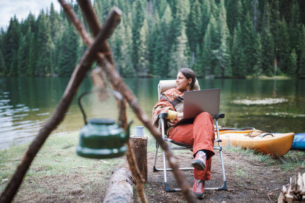 istock Young woman using her laptop while she is at nature. 1305189910