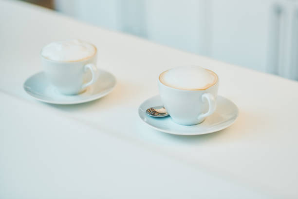 Shot of two cups of coffee on a counter in a cafe