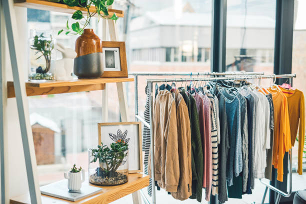 All kinds of clothes to suit your personal style Shot of clothing hanging on a rack in an empty boutique clothing store stock pictures, royalty-free photos & images