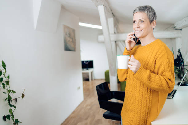 istock Beautiful woman having a phone conversation at home 1305191328