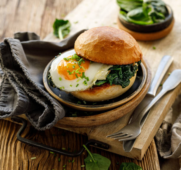 istock Vegetarian burger with fried egg and spinach sprinkled with chive 1305192650