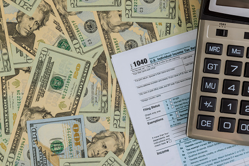 Individual Income Tax date time return form 1040 U.S. with calculator on US american dollars
