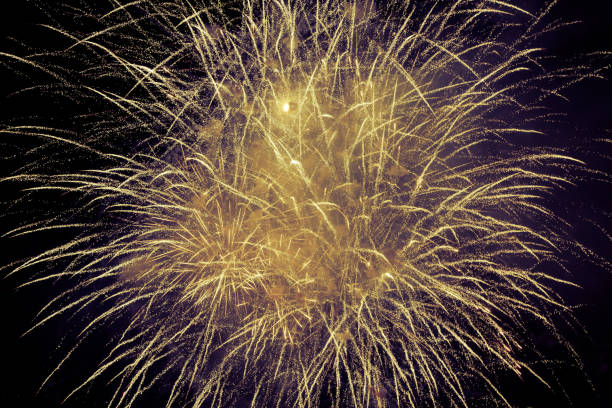 amazing abstract view of amazing natural, golden colored firework blast, explosion on dark sky background stock photo