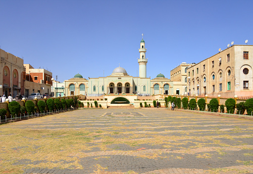 Asmara, Eritrea: Great Mosque of Asmara, Al Kulafah Al Rashidan (Salem Street / Via Piemonte) and its square used for ablutions (former Largo Puglie) used for ablutions, facing Nakfa Avenue / Corso del Re - built in 1938, architect Guido Ferrazza, blend of the architectural styles of Rationalist, Classical, and Islamic - novecento facades on the Mosque square - Asmera, a Modernist City of Africa - UNESCO World Heritage Site