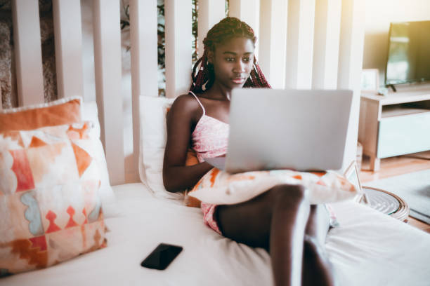 istock Black girl on the bed using a laptop 1305211681