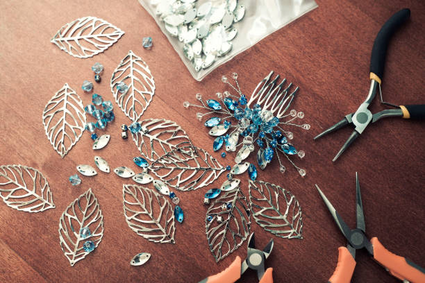 istock The process of creating jewelry with wire, rhinestones and crystals. Working tools on the table. Handmade jewelry. A bridal comb in the manufacturing process. 1305214428