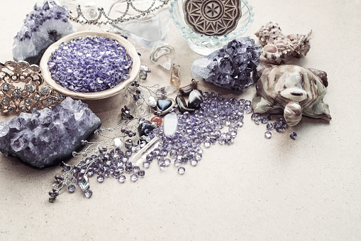 Beautiful stones, crystals, minerals, and other materials on a cardboard textured surface. Magic crystals and products.