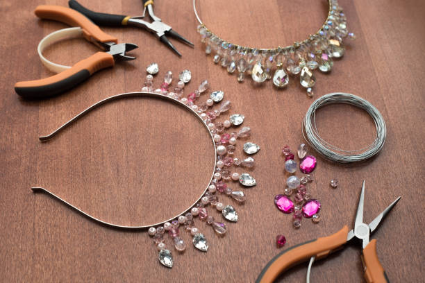 istock The process of creating jewelry from wire and crystals. Working tools on the table. Handmade jewelry. Homemade products. The crown for the bride in the manufacturing process. 1305214939