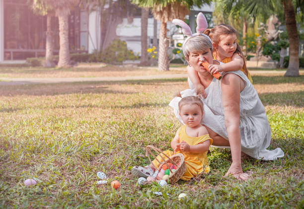 子供を持つ女性は草の上で楽しんでいます - easter easter bunny fun humor ストックフォトと画像