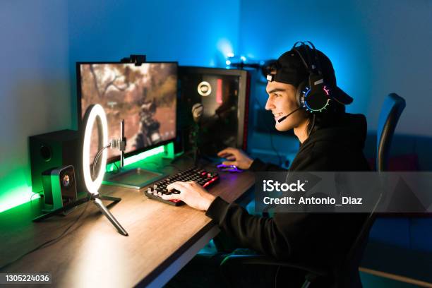 Latin Man Gaming On His Pc During A Live Stream Stock Photo - Download Image Now - Video Game, Gamer, Desktop PC