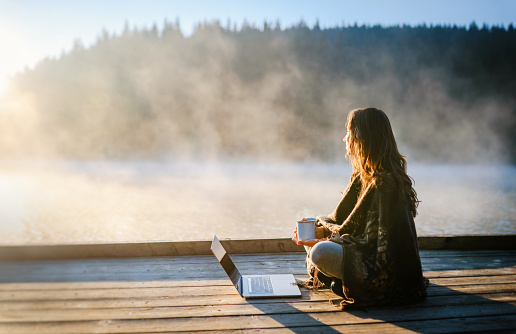 Mujer relajándose en la naturaleza y usando tecnología photo