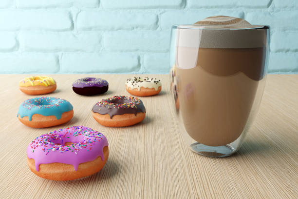 カラフルなアイシングとカラフルなふりかけと木製のテーブルの背景に泡とコーヒーのカップとおいしいドーナツ。 - donut caffeine coffee cream ストックフォトと画像