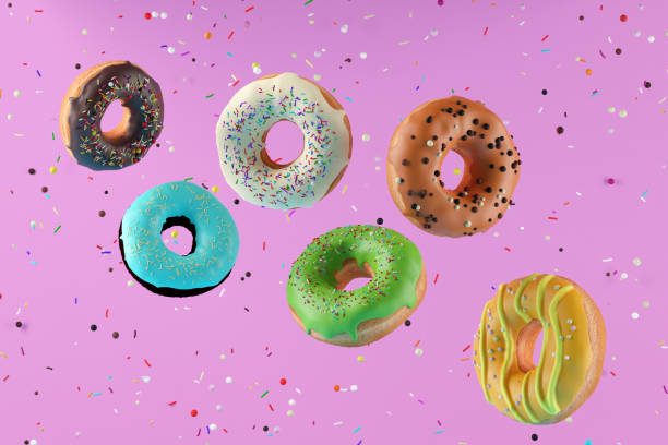 istock Colorful flying doughnuts with sprinkles on pink background. 1305230221
