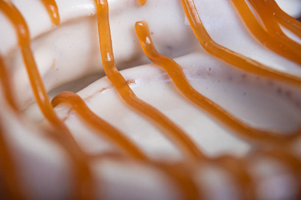 istock Exquisite creamy cinnamon roll with white coating garnished with caramel. 1305233506