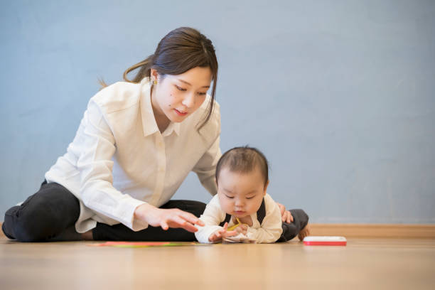 istock Mom playing with baby indoors 1305235267