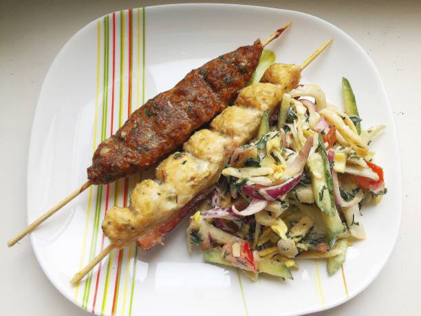 istock lula kebab with fresh vegetable salad on a white plate. 1305236170