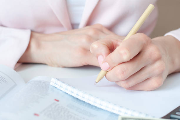 istock a woman writes down information with a pen in a diary 1305241194