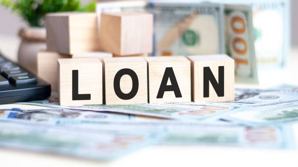 istock wooden blocks with text Loan and banknotes on table, concept 1305241199