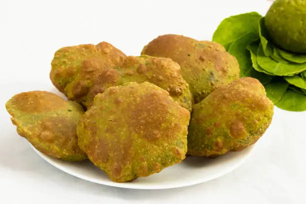 Photo of Healthy Herbal Food Theme. Famous Indian Karare Palak Poori Or Spinach Masala Puri Made Of Gehoon Ka Aata Whole Wheat Flour. Knead Dough And Green Leaves On White Background With Blank Space For Text