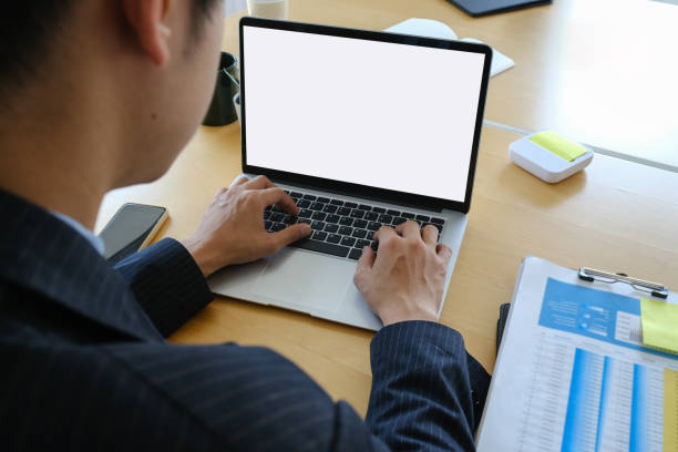 istock Rear view of businessman working on laptop computer and  analyzing data report at office desk. 1305242964