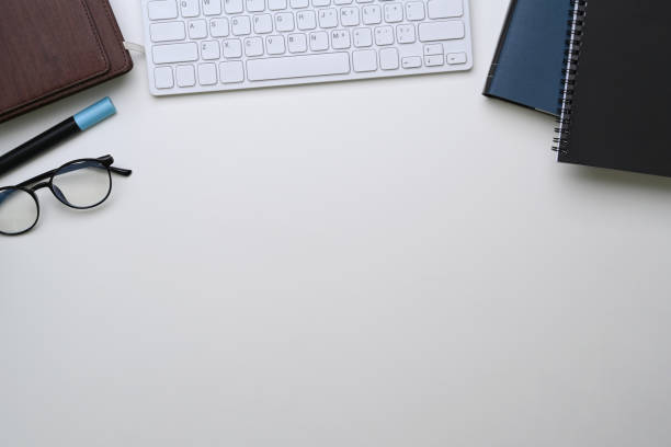 istock White office desk with notebook, keyboard, glasses and copy space. 1305243231