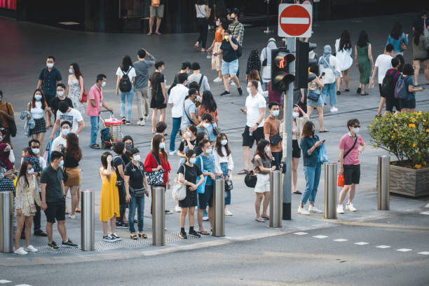 Orchard Road crossing in Singapore The Orchard Road crossing in Singapore is one of the busiest in the world, here seen an afternoon during the Covid-19 corona pandemics in October 2020. All people wearing masks to protect themselves. covid crowd stock pictures, royalty-free photos & images