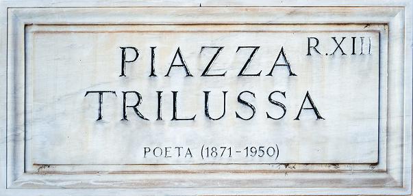 The typical travertine marble plaque with an indication of a street or a square in the historic center of Rome. In the picture: Piazza Trilussa, in the ancient quarter of Trastevere.