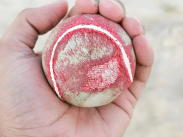 Photo of An old Tennis Ball in Red Color in hand