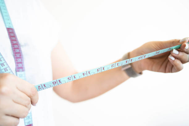 istock Woman's hand holding tailor measuring tape 1305248277
