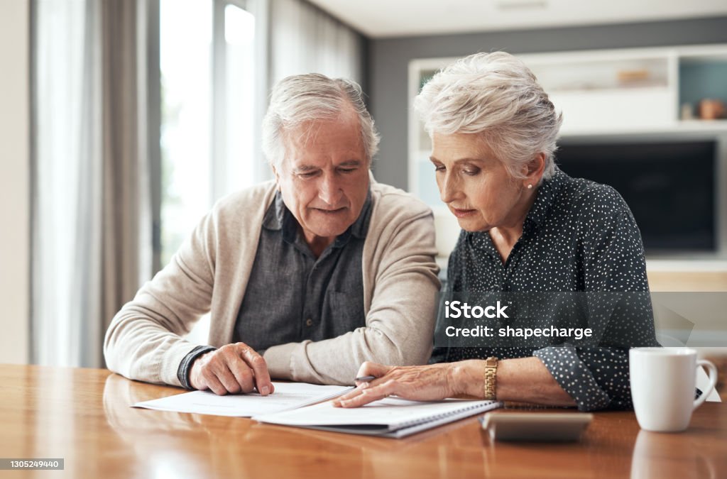 I want to reinvest this Cropped shot of a senior couple sitting together and going through their finances at home Will - Legal Document Stock Photo