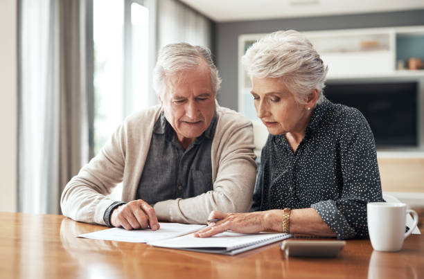 I want to reinvest this Cropped shot of a senior couple sitting together and going through their finances at home will legal document stock pictures, royalty-free photos & images