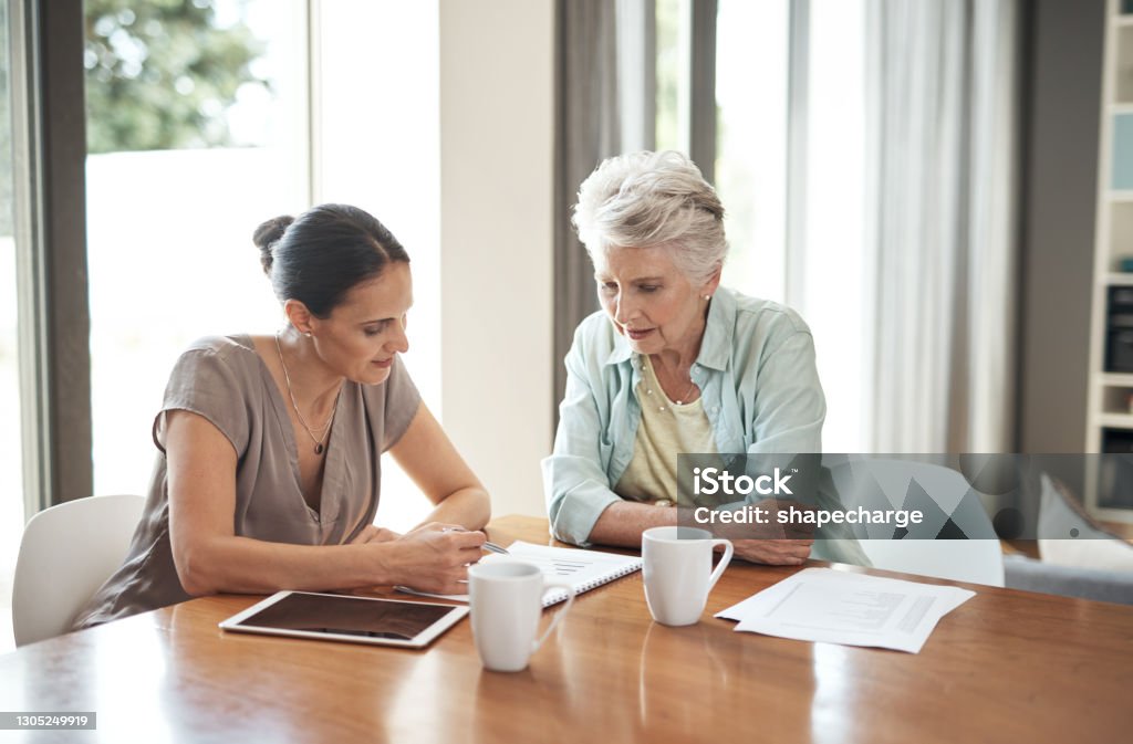 My daughter helps me keep my finances in check Cropped shot of an attractive young woman assisting her elderly mother with her finances at home Will - Legal Document Stock Photo