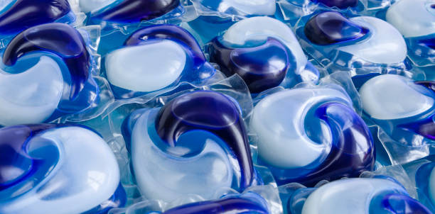 blue capsules Lots of blue capsules with pre-dosed detergent, gel, powder in capsules for easy washing of laundry. Background. copy space for text detergent capsule stock pictures, royalty-free photos & images