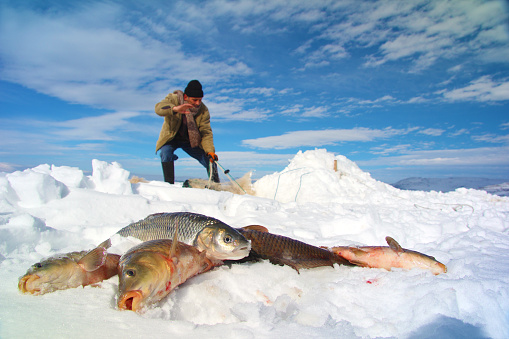Fisherman fishing on the frozen Cildir lake at Kars Turkey