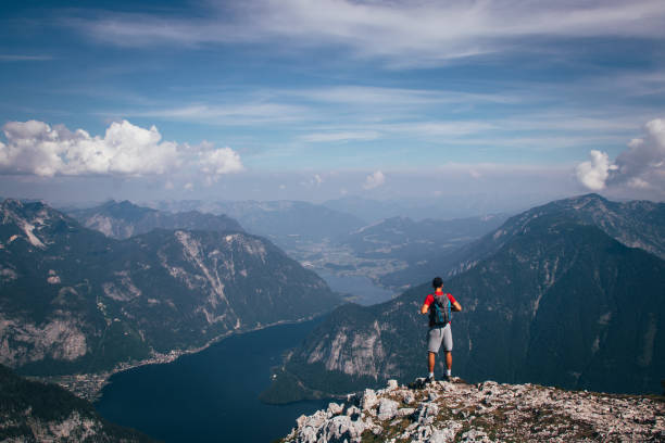 istock man with a backpack takes in Austrian nature and a hallstatter see from Mount Krippenstein. A sense of relaxation and freedom. The sporty type enjoys the feeling of victory over this mountain 1305251545