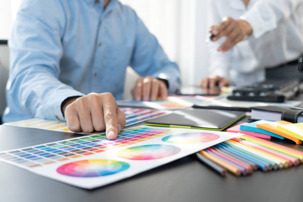 istock Graphic designer or creative working together coloring using graphics tablet and a stylus at desk with colleague 1305253663