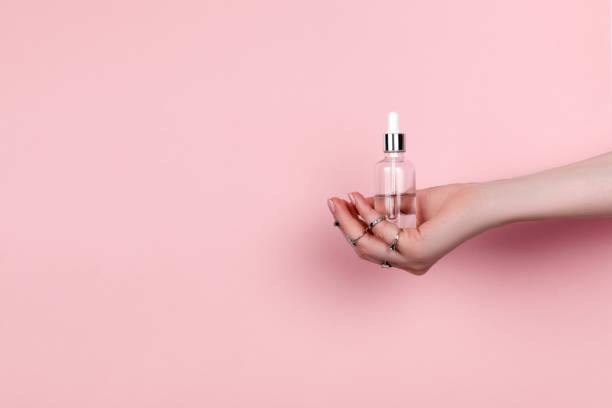 istock Female hand holding hyaluronic bottle from torn paper 1305253712