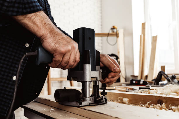 istock Carpenter cutting wood with electric jigsaw close up 1305255614