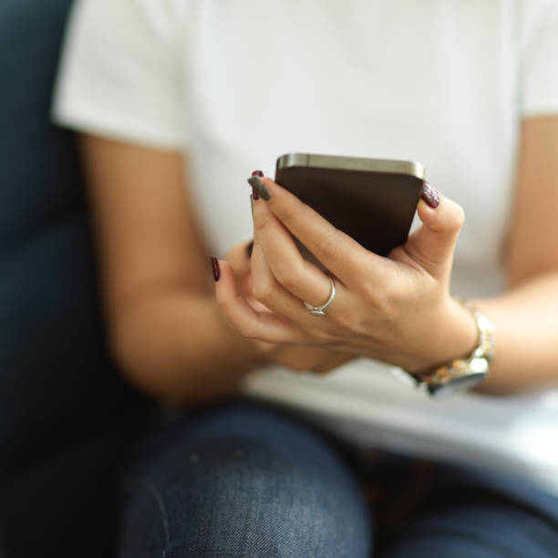 istock Female office worker using smartphone in her hands while relaxing in cafe 1305256619