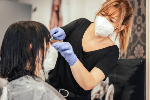 istock Cutting the bangs to a client with security measures. Reopening with security measures of Hairdressers in the Covid-19 pandemic 1305256930