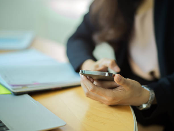 istock Businesswoman using smartphone in her hands while sitting at workplace 1305257215