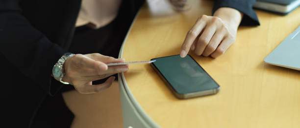 istock Businesswoman online paying on smartphone while sitting at workplace 1305257289