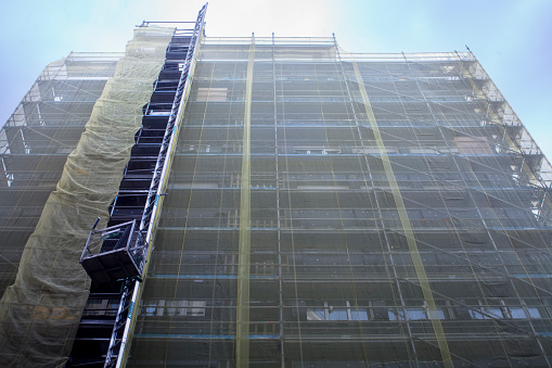 Scaffolding detail, construction site,  tall building, covering net. Asturias, Spain.