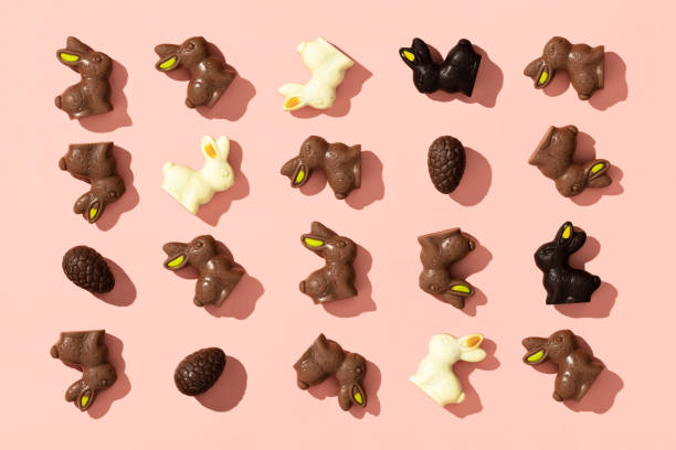 Chocolate Easter Eggs and Bunnies on pink background pattern Chocolate Easter Eggs and Bunnies on pink background pattern, flat lay chocolate bunny stock pictures, royalty-free photos & images