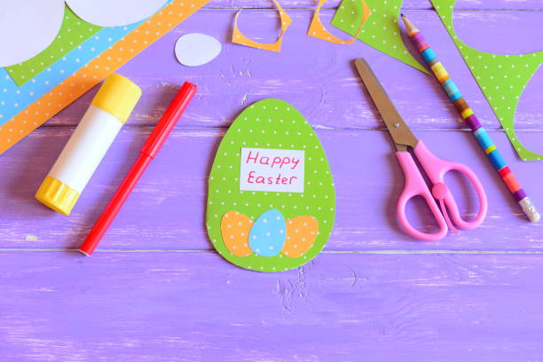 istock Happy Easter greeting card in egg shape. Easter creative paper cut egg greeting card crafts for kids. Materials and tools for children's art creativity. Easter holiday paper cut art crafts concept for kids 1305262342