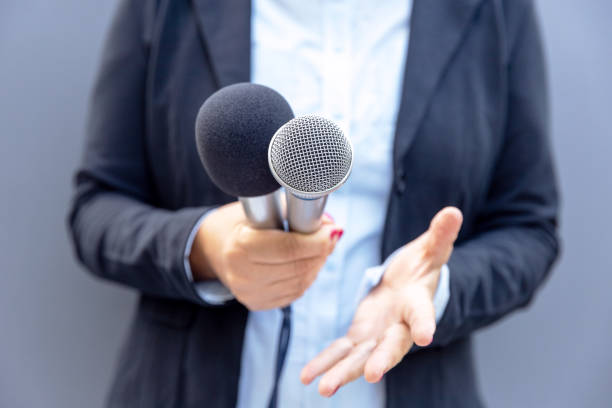 istock Journalist or TV reporter holding microphone and making media interview. Broadcast journalism concept. 1305262423
